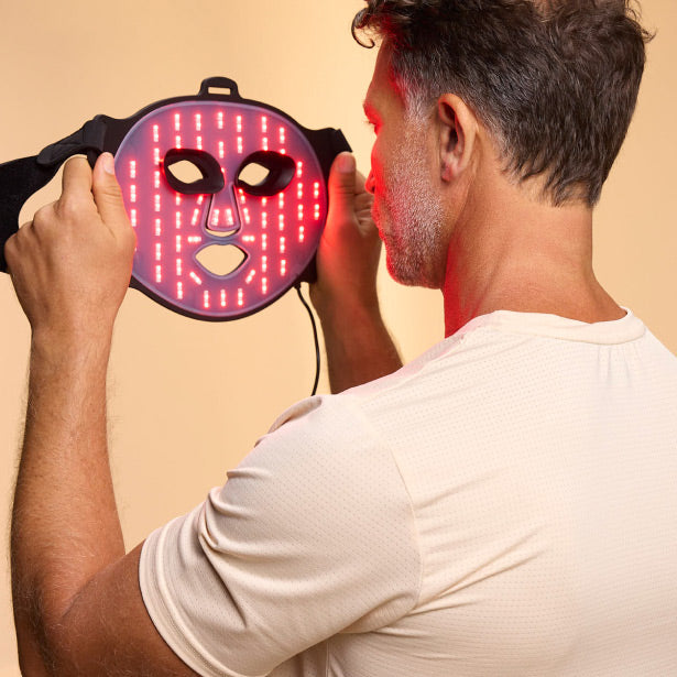 Man Facing Back Holding A Red Light Face Mask